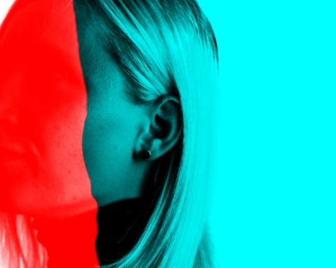 A photo of a blonde woman, whose face is obscured by bright red and blue color blocks.