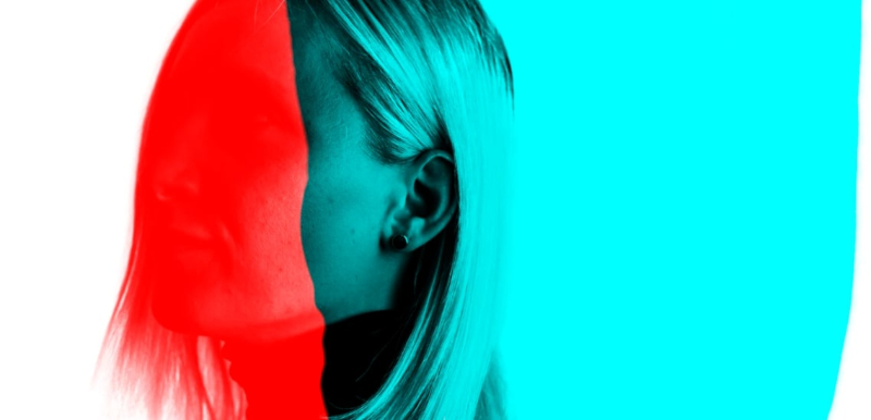 A photo of a blonde woman, whose face is obscured by bright red and blue color blocks.