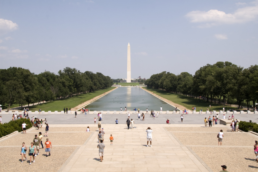 A sun-drenched image of the Reflecting Pool and the National Monument in Washington, DC