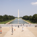 A sun-drenched image of the Reflecting Pool and the National Monument in Washington, DC