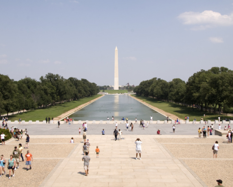 A sun-drenched image of the Reflecting Pool and the National Monument in Washington, DC