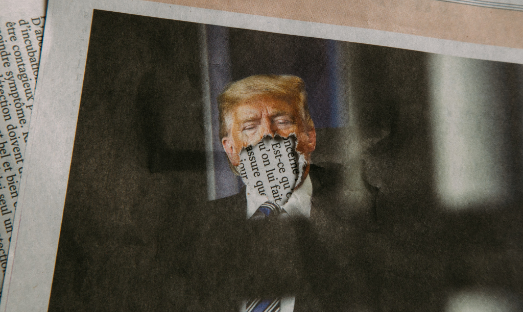 An photograph of Donald Trump in the newspaper, except his mouth has been ripped off.