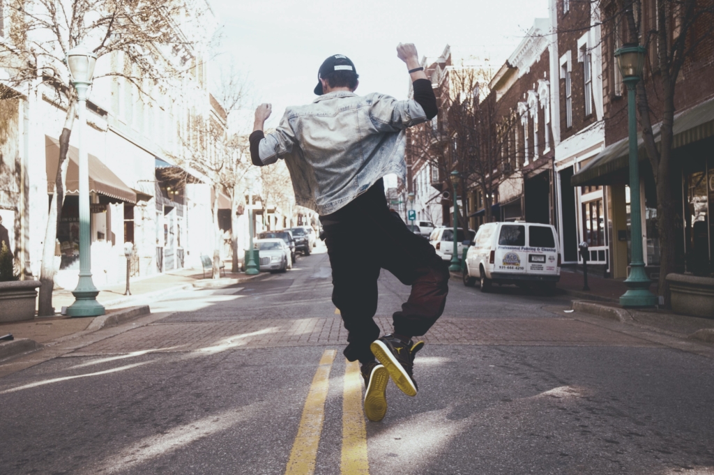 A man jumps in the street in joy.