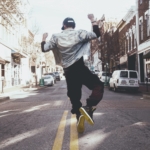 A man jumps in the street in joy.