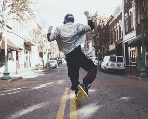 A man jumps in the street in joy.