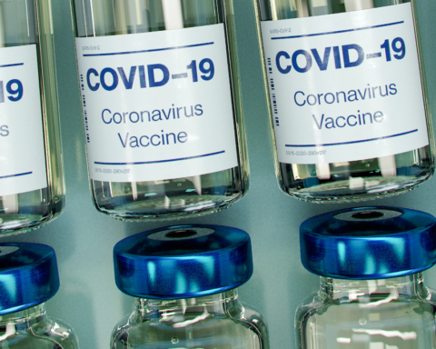 A photo of glass vials labeled "Covid-19 Vaccine"