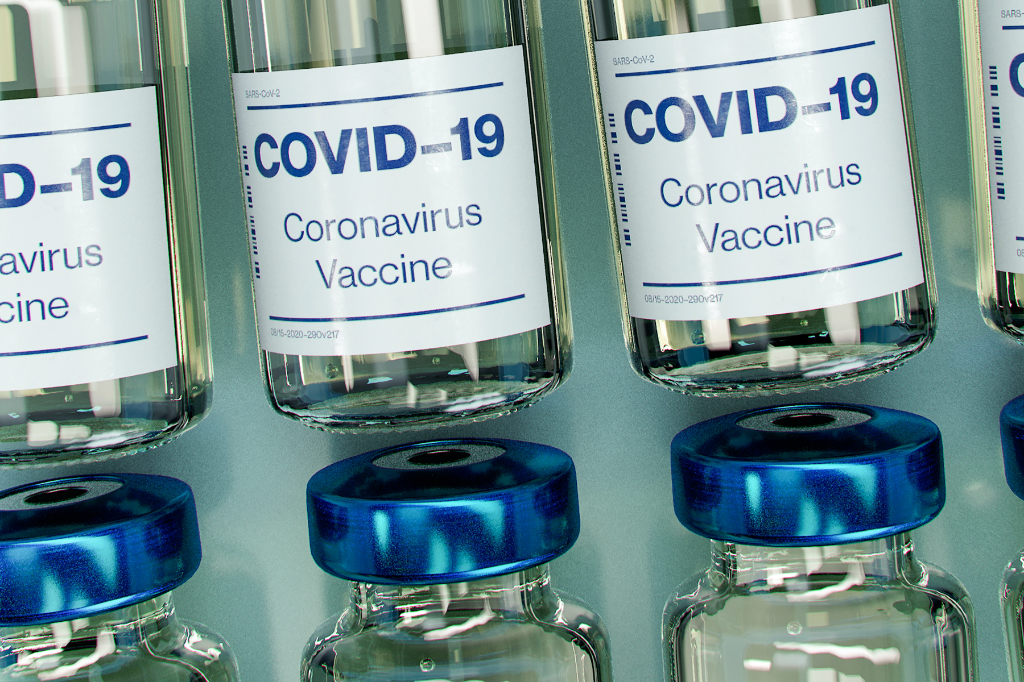 A photo of glass vials labeled "Covid-19 Vaccine"