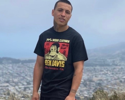 A photo of Sean Monterrosa, standing on a hill in front of a city.