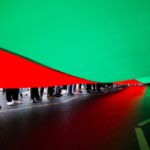 Under the flag of Afghanistan, the feet of a crowd.