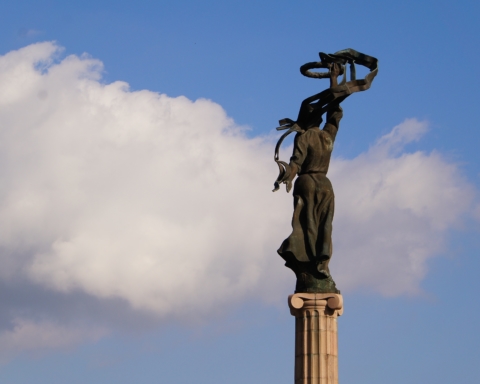 In this photograph taken in Ukraine, a sculpture lifts a ribbon to in the sky.