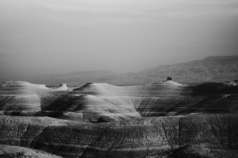 Stark black and white photograph of a bare mountain ridge in the West Bank of Palestine.